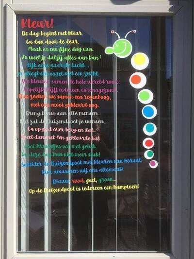 Raamsticker met kleurrijke tekst op een glazen raam